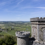 A castle tower overlooking a green valley.